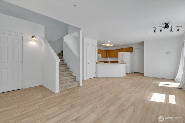 2064 Mcdonald Ave, Dupont, WA 98327 - unfurnished living room with light wood-style flooring and stairway