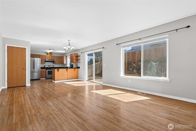 26822 27th Ave S, Kent, WA 98032 - unfurnished living room with a chandelier and light wood finished floors