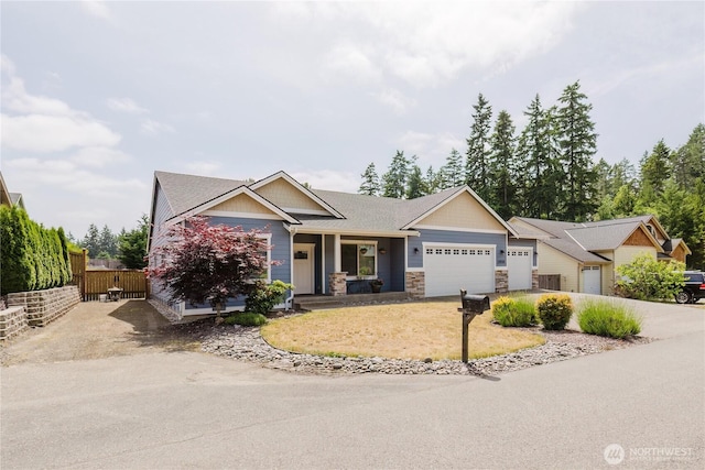 11928 Mayfair Ave SW, Port Orchard, WA 98367 - craftsman house featuring an attached garage, stone siding, covered porch, and concrete driveway
