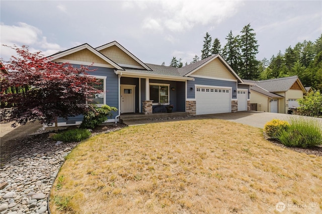11928 Mayfair Ave SW, Port Orchard, WA 98367 - craftsman-style home with an attached garage, stone siding, a front lawn, driveway, and a porch