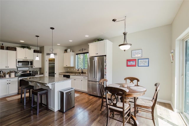 11928 Mayfair Ave SW, Port Orchard, WA 98367 - kitchen featuring stainless steel appliances, white cabinetry, a center island, a kitchen breakfast bar, and recessed lighting
