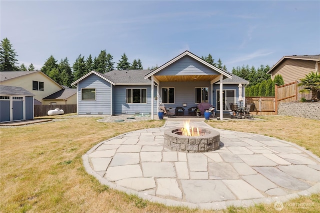 11928 Mayfair Ave SW, Port Orchard, WA 98367 - back of property featuring an outdoor fire pit, a patio area, a storage shed, and a fenced backyard