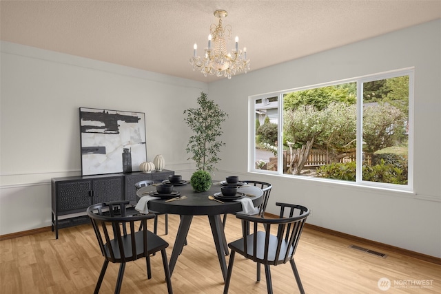 13016 8th Pl SW, Burien, WA 98146 - dining space featuring a chandelier, light wood-type flooring, and a textured ceiling