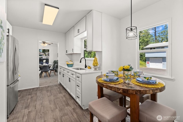 29260 Military Rd S, Federal Way, WA 98003 - kitchen with freestanding refrigerator, wood finished floors, light countertops, and white cabinetry