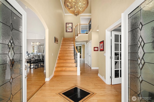 13804 SE 76th Pl, Newcastle, WA 98059 - entryway featuring a chandelier, a high ceiling, wood finished floors, stairway, and arched walkways