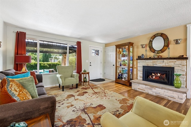 1227 137th St E, Tacoma, WA 98445 - living room with wood finished floors, a fireplace, and a textured ceiling