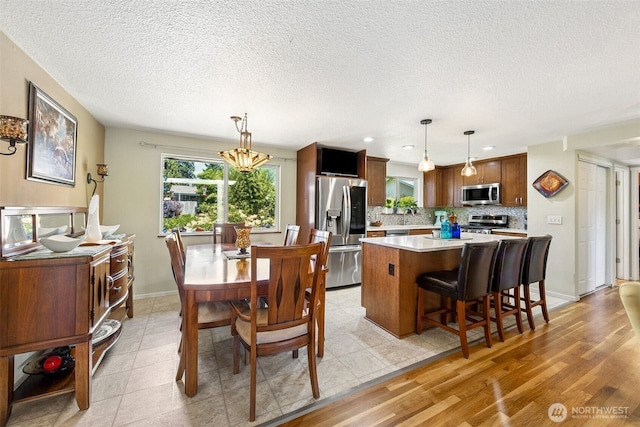 1227 137th St E, Tacoma, WA 98445 - dining room featuring a textured ceiling, recessed lighting, and light wood finished floors