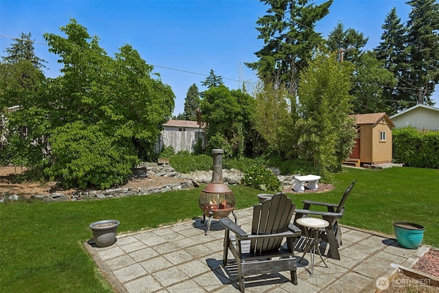 1227 137th St E, Tacoma, WA 98445 - view of patio with an outdoor fire pit and a storage shed