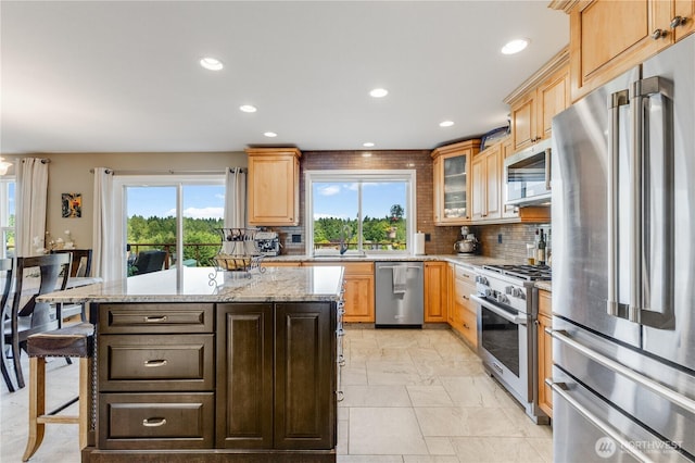 23017 138th Ave E, Graham, WA 98338 - kitchen with appliances with stainless steel finishes, recessed lighting, light stone countertops, decorative backsplash, and a center island