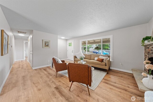 5257 N Dahl Dr, Tacoma, WA 98406 - living area with light wood finished floors, a textured ceiling, and a fireplace
