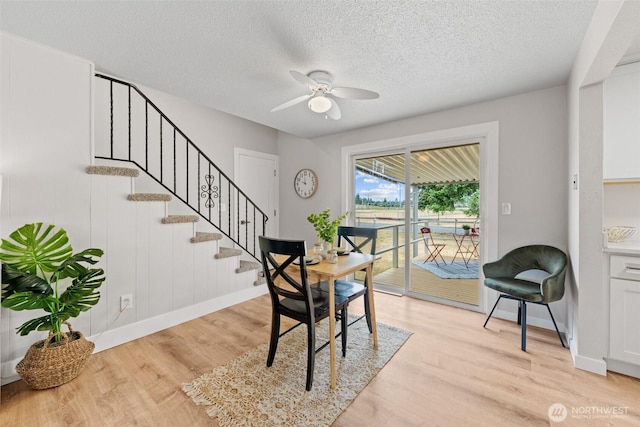 5257 N Dahl Dr, Tacoma, WA 98406 - dining area featuring a ceiling fan, light wood-style floors, a textured ceiling, and stairs