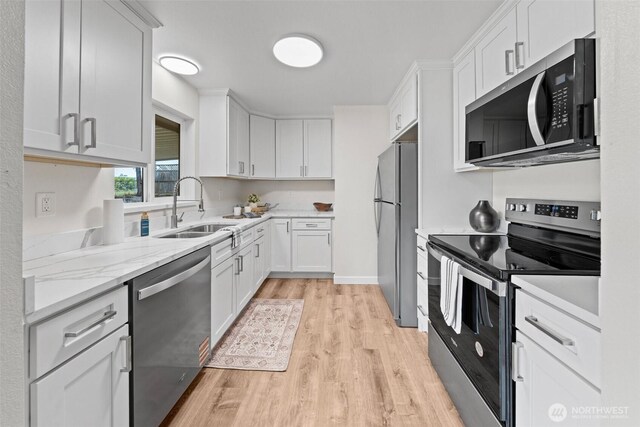 5257 N Dahl Dr, Tacoma, WA 98406 - kitchen featuring appliances with stainless steel finishes, light wood-style flooring, white cabinetry, and light stone counters