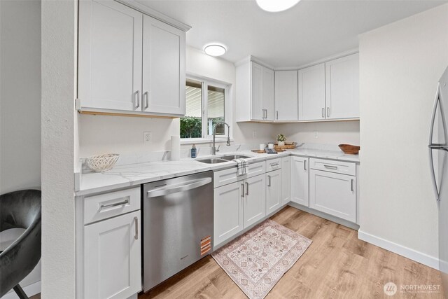 5257 N Dahl Dr, Tacoma, WA 98406 - kitchen with stainless steel dishwasher, light wood-type flooring, white cabinets, and light stone counters