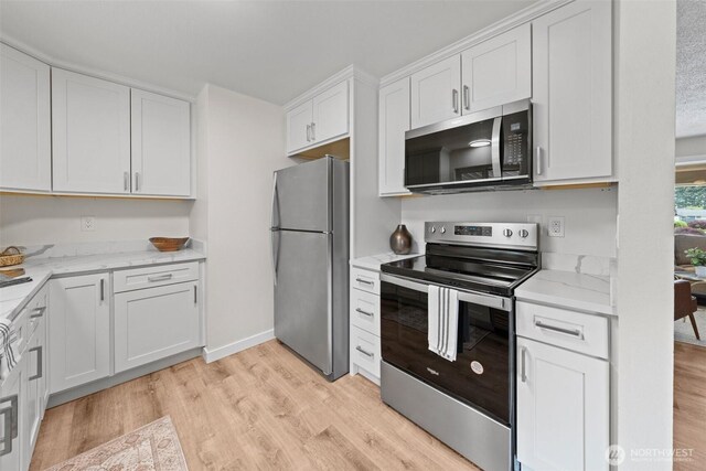 5257 N Dahl Dr, Tacoma, WA 98406 - kitchen featuring stainless steel appliances, light wood-style flooring, white cabinets, and light stone countertops