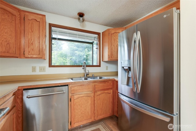 1264 SW Lanyard Loop Unit 2, Oak Harbor, WA 98277 - kitchen with appliances with stainless steel finishes, a textured ceiling, light countertops, and brown cabinetry