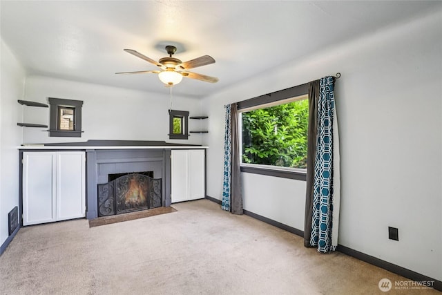 1004 S 5th Ave, Kelso, WA 98626 - unfurnished living room featuring a lit fireplace, a ceiling fan, and carpet flooring