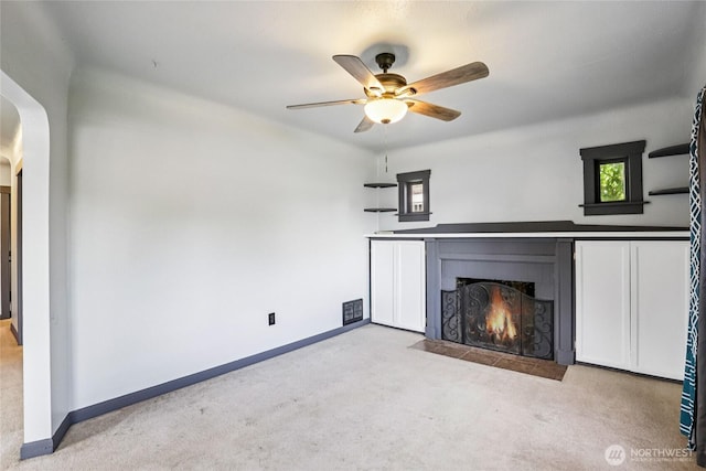 1004 S 5th Ave, Kelso, WA 98626 - unfurnished living room with a fireplace with flush hearth, carpet floors, a ceiling fan, and arched walkways