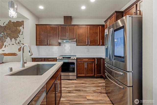 2015 79th St SE, Everett, WA 98203 - kitchen featuring appliances with stainless steel finishes, under cabinet range hood, wood finished floors, recessed lighting, and backsplash