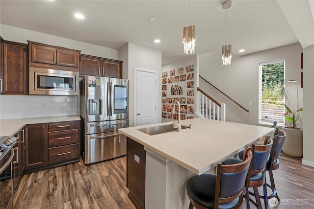 2015 79th St SE, Everett, WA 98203 - kitchen featuring stainless steel appliances, dark wood-type flooring, dark brown cabinets, tasteful backsplash, and pendant lighting