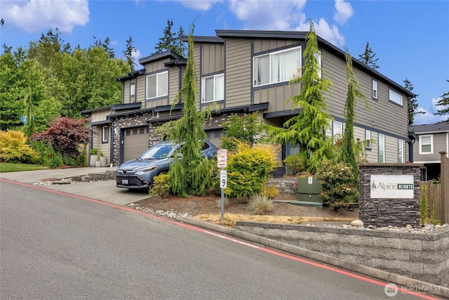 2015 79th St SE, Everett, WA 98203 - view of front of house with board and batten siding, driveway, an attached garage, and stone siding