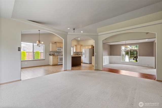 4703 235th St E, Spanaway, WA 98387 - unfurnished living room with a chandelier, light colored carpet, plenty of natural light, recessed lighting, and wainscoting