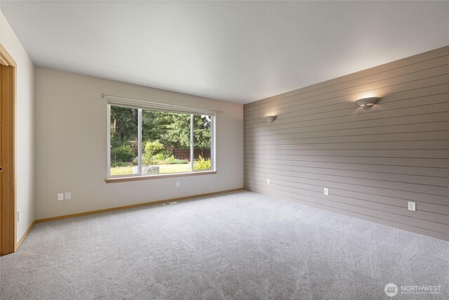 4703 235th St E, Spanaway, WA 98387 - carpeted spare room with wooden walls and baseboards