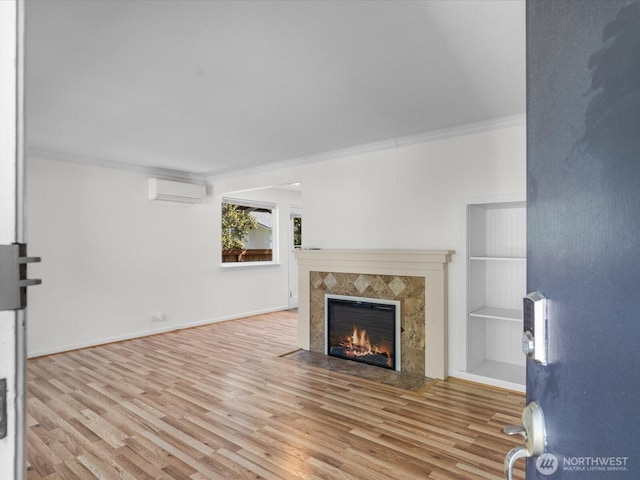 14324 Wayne Pl N, Seattle, WA 98133 - unfurnished living room featuring a wall mounted air conditioner, ornamental molding, a tiled fireplace, and wood finished floors