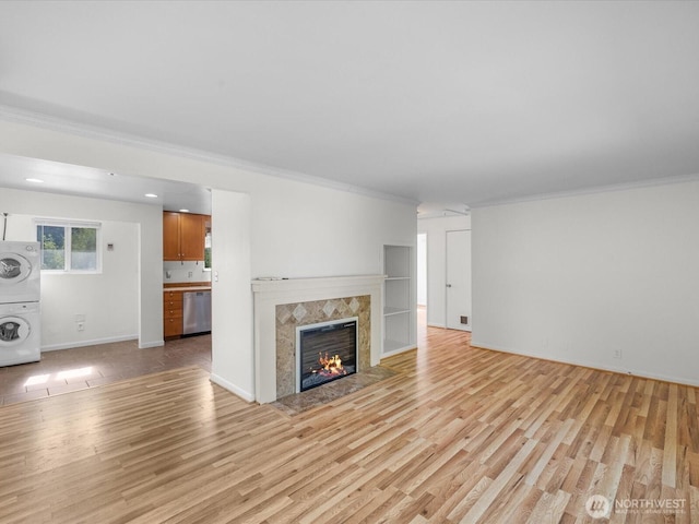 14324 Wayne Pl N, Seattle, WA 98133 - unfurnished living room with stacked washer and clothes dryer, ornamental molding, light wood-type flooring, and a premium fireplace