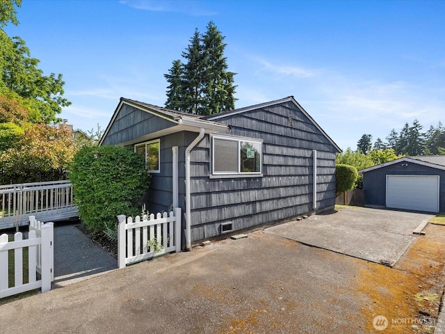 14324 Wayne Pl N, Seattle, WA 98133 - view of home's exterior featuring concrete driveway, a detached garage, and an outdoor structure