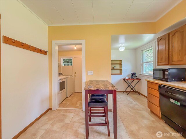 5302 Rockefeller Ave, Everett, WA 98203 - kitchen with black appliances, light tile patterned flooring, and washing machine and clothes dryer