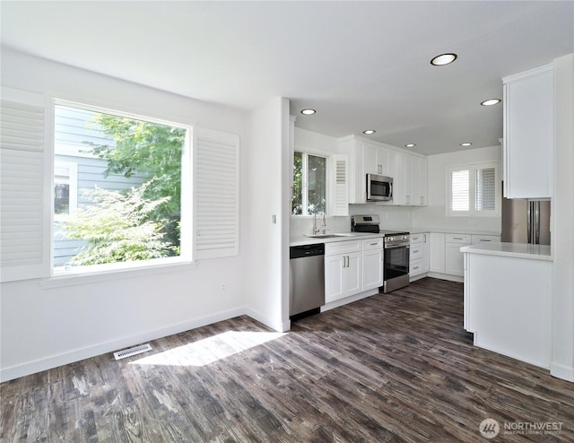 10105 6th Dr SE Unit B, Everett, WA 98208 - kitchen with appliances with stainless steel finishes, white cabinetry, dark wood finished floors, light countertops, and recessed lighting