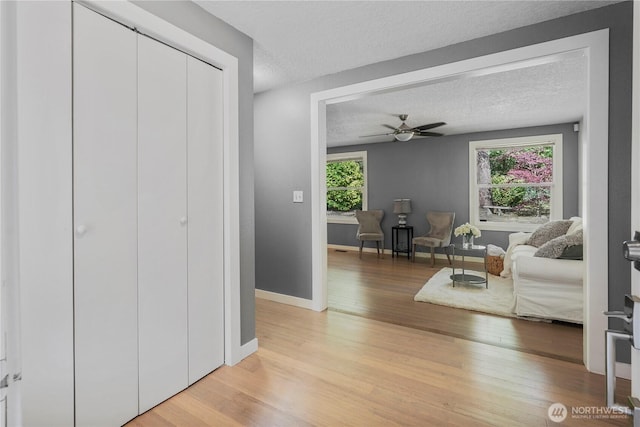 13719 Pinehurst Ln NW, Gig Harbor, WA 98329 - living area featuring light wood-style flooring, a textured ceiling, and a ceiling fan