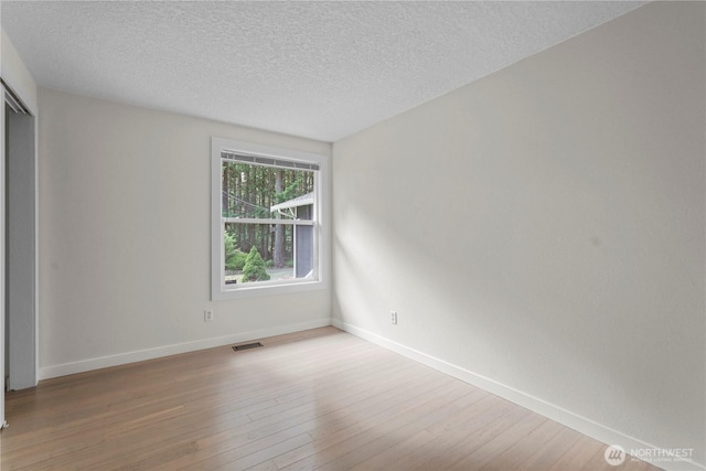 13719 Pinehurst Ln NW, Gig Harbor, WA 98329 - empty room with wood finished floors and a textured ceiling