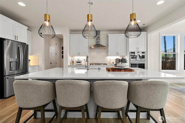 18740 130th St E, Bonney Lake, WA 98391 - kitchen featuring appliances with stainless steel finishes, wall chimney exhaust hood, decorative backsplash, recessed lighting, and light countertops