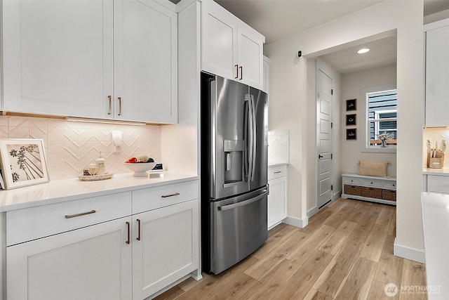 18740 130th St E, Bonney Lake, WA 98391 - kitchen featuring stainless steel refrigerator with ice dispenser, white cabinets, light wood-style floors, light countertops, and decorative backsplash