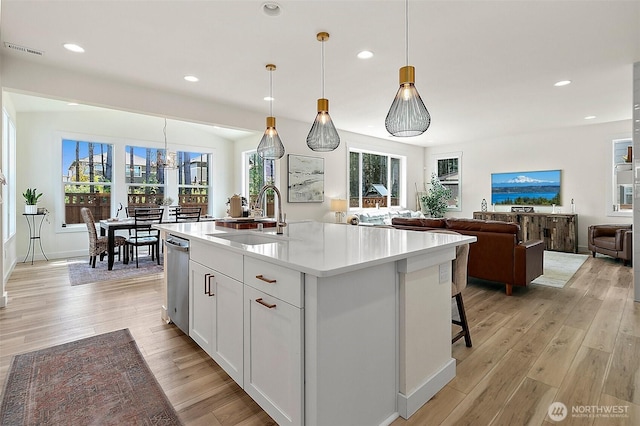 18740 130th St E, Bonney Lake, WA 98391 - kitchen featuring stainless steel dishwasher, light countertops, light wood finished floors, healthy amount of natural light, and recessed lighting