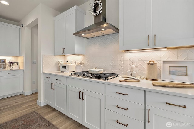 18740 130th St E, Bonney Lake, WA 98391 - kitchen with wall chimney exhaust hood, stainless steel gas stovetop, light countertops, light wood-style floors, and recessed lighting