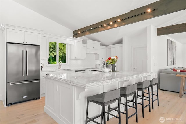 3231 Northshore Rd, Bellingham, WA 98226 - kitchen featuring high end refrigerator, tasteful backsplash, white cabinets, light wood finished floors, and a large island with sink