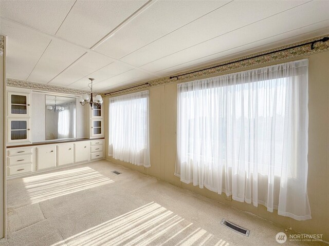 610 W Spruce St Unit 116, Sequim, WA 98382 - unfurnished dining area with a chandelier and light colored carpet