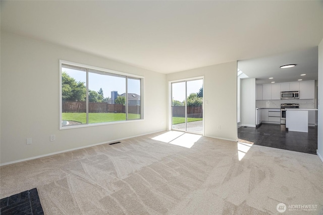 9825 S 246th Pl, Kent, WA 98030 - unfurnished living room featuring dark colored carpet and baseboards