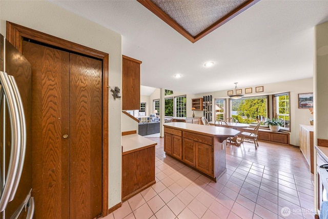21 Longshore Ln, Bellingham, WA 98229 - kitchen featuring freestanding refrigerator, brown cabinets, light countertops, light tile patterned floors, and recessed lighting