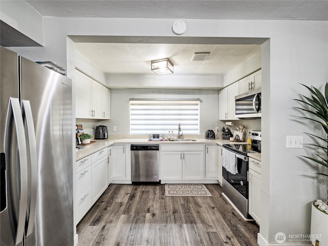 404 Nixon St S, Roy, WA 98580 - kitchen featuring stainless steel appliances, dark wood-style floors, white cabinetry, and a textured ceiling