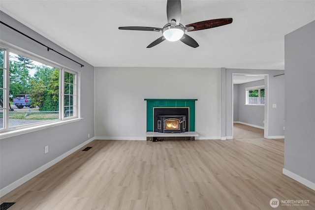 4801 78th St E, Tacoma, WA 98443 - unfurnished living room featuring light wood-type flooring, a ceiling fan, and a warm lit fireplace
