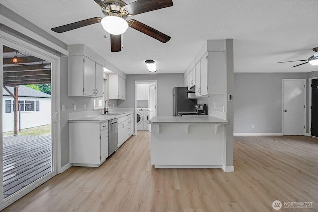 4801 78th St E, Tacoma, WA 98443 - kitchen featuring stainless steel dishwasher, washing machine and dryer, a ceiling fan, light wood-style flooring, and light countertops