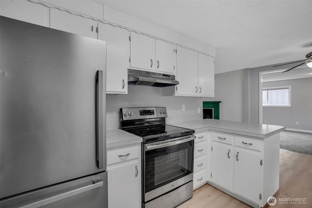 4801 78th St E, Tacoma, WA 98443 - kitchen featuring appliances with stainless steel finishes, under cabinet range hood, light countertops, light wood finished floors, and white cabinetry