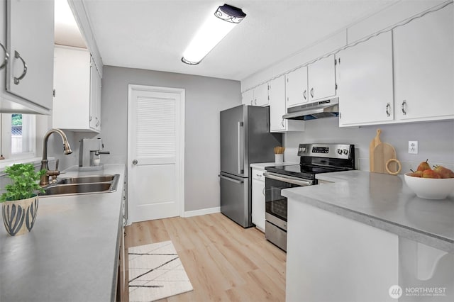 4801 78th St E, Tacoma, WA 98443 - kitchen with stainless steel appliances, under cabinet range hood, light wood-style floors, light countertops, and white cabinets