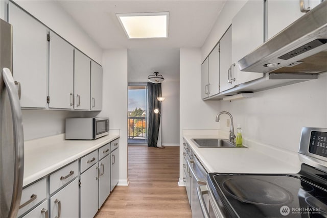 4540 8th Ave NE Unit 1102, Seattle, WA 98105 - kitchen featuring extractor fan, stainless steel appliances, light wood finished floors, and light countertops