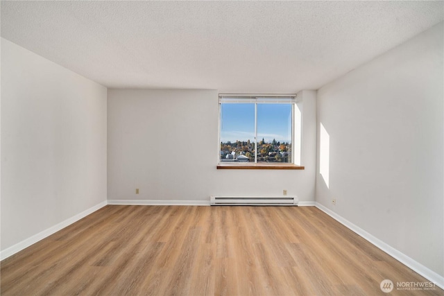4540 8th Ave NE Unit 1102, Seattle, WA 98105 - unfurnished room with a baseboard radiator, wood finished floors, and a textured ceiling