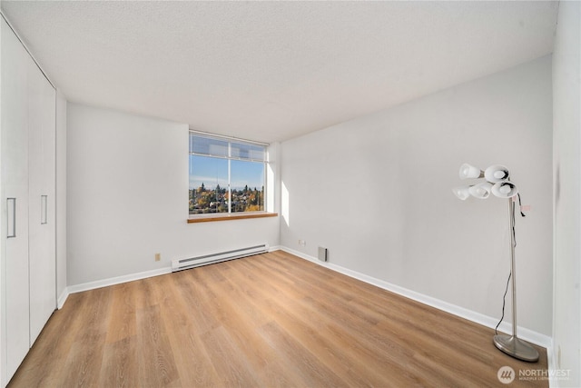 4540 8th Ave NE Unit 1102, Seattle, WA 98105 - spare room featuring baseboard heating and wood finished floors