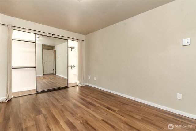 7308 N Skyview Ln Unit I-304, Tacoma, WA 98406 - unfurnished bedroom with dark wood-style flooring and baseboards